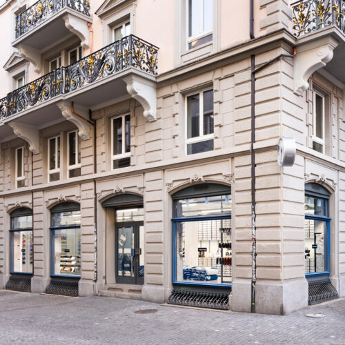 Blau gerahmte Bogenfenster fügen sich in die historische Fassade am Hirschenplatz ein