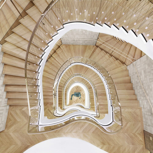 Das Herzstück bildet eine skulpturale Wendeltreppe mit wellenförmigen Balustraden.