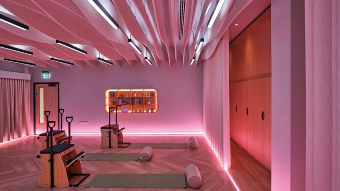 Der Fitness- und Pilates-Bereich ist in ein sanftes, rosafarbenes Licht getaucht