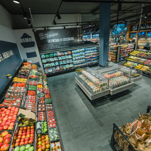 Ein Piktogramm des Leuchtturmes heißt Kund:innen in der Obst- und Gemüseabteilung willkommen.