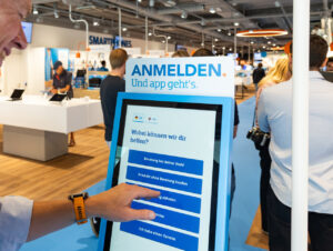 An der Willkommenssäule melden sich Kund:innen per Touchscreen zur Beratung oder Abholung an