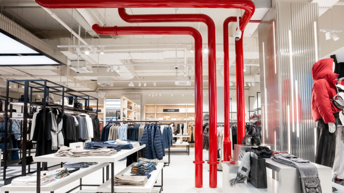 Markante Rohrelemente in hochglänzendem Finish setzen vertikale Akzente und verstärken die CI-Farbgebung 