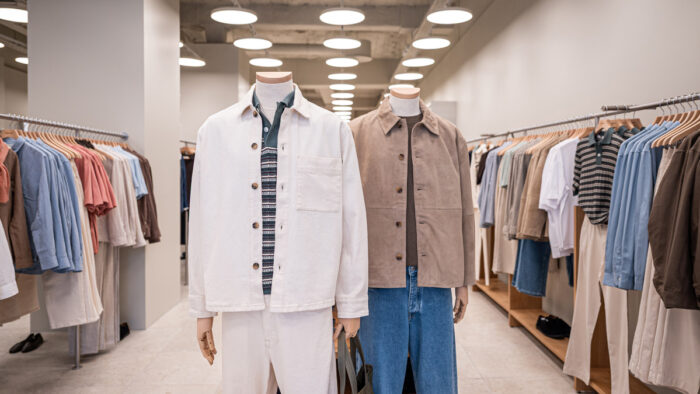 Großzügige Laufwege, zentrale Mannequin-Inszenierung und kreisrunde Pendelleuchten prägen die Raumatmosphäre