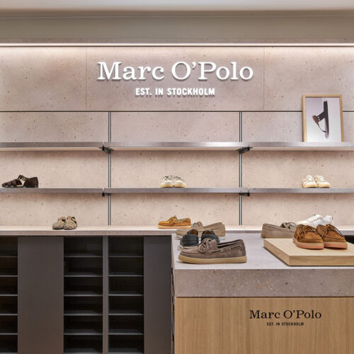 Die hinterleuchtete Rückwand mit Marc O'Polo-Branding bildet den optischen Ankerpunkt