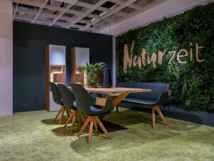 Eine begrünte Wandinstallation inszeniert das Massivholzsortiment