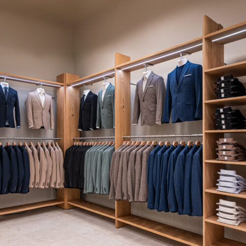 Wandregalanlage in Eichenholz mit Hängeware, Frontpräsentation und integrierter LED-Beleuchtung