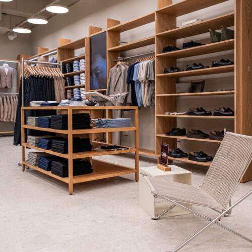 Flexibel einsetzbare Holzmöbel, ergänzt durch einen Designsessel als wohnlichen Akzent