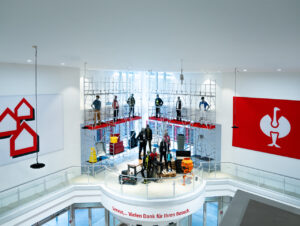 Ein Baugerüst mit Schaufensterpuppen und großformatige Markenlogos inszenieren die Kooperation im Atrium