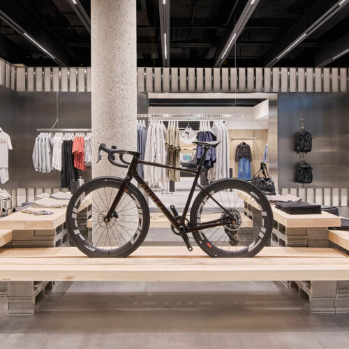 Im „Zara Athleticz"-Bereich im Obergeschoss dient ein Rennrad als zentrales Displayelement auf einer Holzplattform mit Beton-Sockel