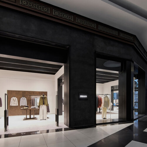 Die dunkel verkleidete Ladenfront mit beleuchtetem Schriftzug setzt den Zara Man Store innerhalb der Mall of Berlin optisch klar ab