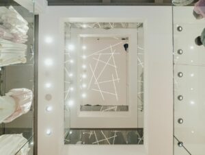 Die räumliche Mitte des Modehauses bildet ein rechteckiger Deckendurchbruch mit einer Mikado-Lichtinstallation.