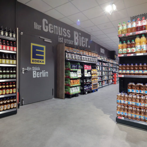 Großformatige Loose-Lay-Fliesen mit Schwalbenschwanz-Verbindung in einer Gussbeton- Optik, lose direkt auf dem Bestandsboden verlegt bei Edeka Reske in Berlin.