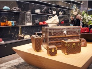 Mit Wänden im Marmorlook und schmalen Regalen setzt Engelhorn Accessoires und Taschen in Szene.