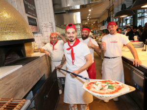 Die Mitarbeiter fühlen sich nahe des Pizzaofens mit Goldmosaik sichtlich wohl. (Foto: Eataly)