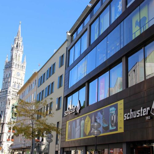 Sporthaus Schuster macht über seine Fassade auf die „Münchens Erste Häuser“-Kampagne aufmerksam.