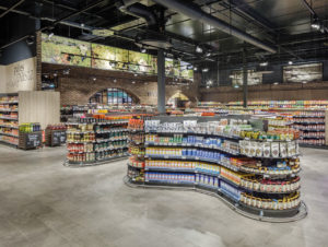 Blick auf die Feinkostabteilung: dunkles Hallen-Ambiente mit grauem Feinsteinzeug-Boden. (Foto: Edeka Kels)