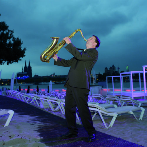 Der Saxophonist bläst gegen die Regenwolken an