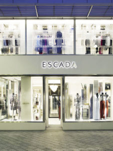 Besonders bei Nacht kommt am Escada-Store in Düsseldorf die Glasfassade zur Geltung, die im oberen Bereich aus handgefertigten Glasfliesen besteht. (Foto: Escada)