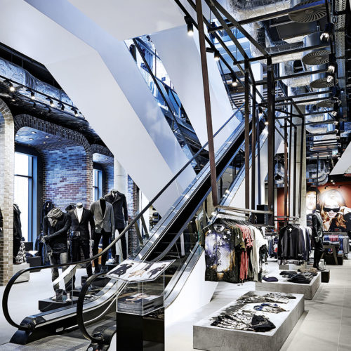 „Hinterhof-Charme“ mit Backstein und offene Rolltreppen-Züge