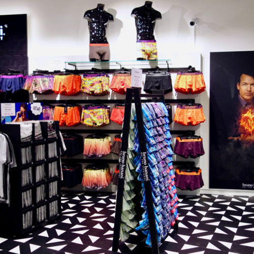 Schwarz und Weiß – das sind die Farben, die die Männerabteilung auf der rund 120 qm großen Fläche von dem Bereich mit der Wäsche für Damen trennen und dem Kunden entsprechende Orientierung bieten. Grautöne setzen Akzente und bilden gewisse Verbindungselemente zischen der Damen- und der Herrenwelt. Die reduzierte Gestaltung der Wandanlagen und die filigranen Mittelraumständer erzeugen ansonsten eine moderne und ansprechende Raumgestaltung. (Foto: Bruno Banani)