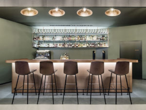 Die Bar als Blickpunkt in einer Komposition aus Kupfer, Lichtreflektionen und einem gedeckten Grün bei „Eduard’s“