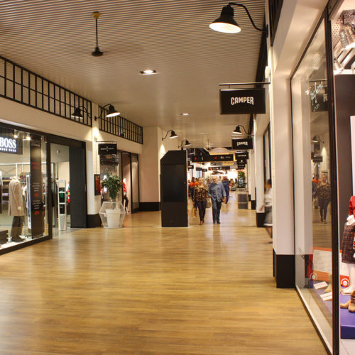 Für maximale Beanspruchung in der Mall des The Style Outlet in Sevilla bietet sich Designbelag an, hier in goldbrauner Eiche-Optik. (Foto: DLW Flooring)
