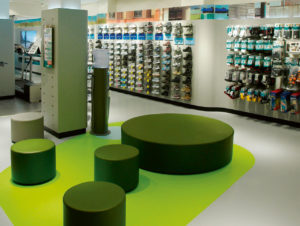 Der hellgraue Kautschuk-Belag im Run2Running-Concept-Store von Runners Point in Düsseldorf mit einer grünen Intarsie soll an Asphalt und Wiese erinnern. (Foto: Nora)