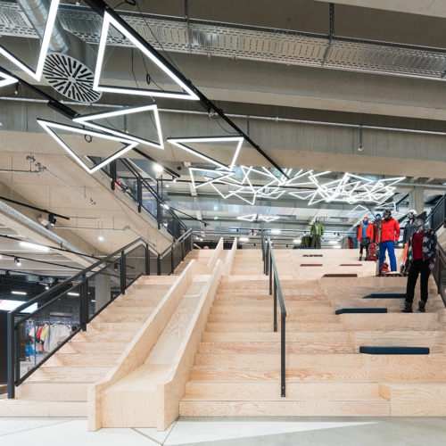 Mittelpunkt des Stores und zugleich verbindendes Element beider Etagen: die bis zu 11 Meter breite Treppe aus Seekiefer