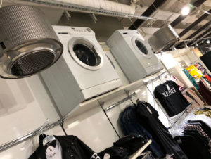 Alte Waschmaschinen, gebrauchte Paletten als Kleiderständer, Surfbretter als Deko, Sperrholz, Papprollen, Wellblech, alte Wassercontainer und Industrieleuchten verhelfen der Young Fashion-Etage U Eins im Modehaus Wöhrl in Nürnberg zusammen mit Möbeln aus dem Bestand zu einem neuen Auftritt. (Foto: Rudolf Wöhrl SE)